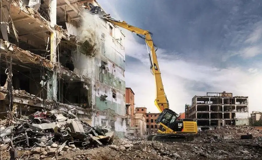 High-reach CAT excavator tearing down multi-story building structure during commercial demolition in Surrey, BC.