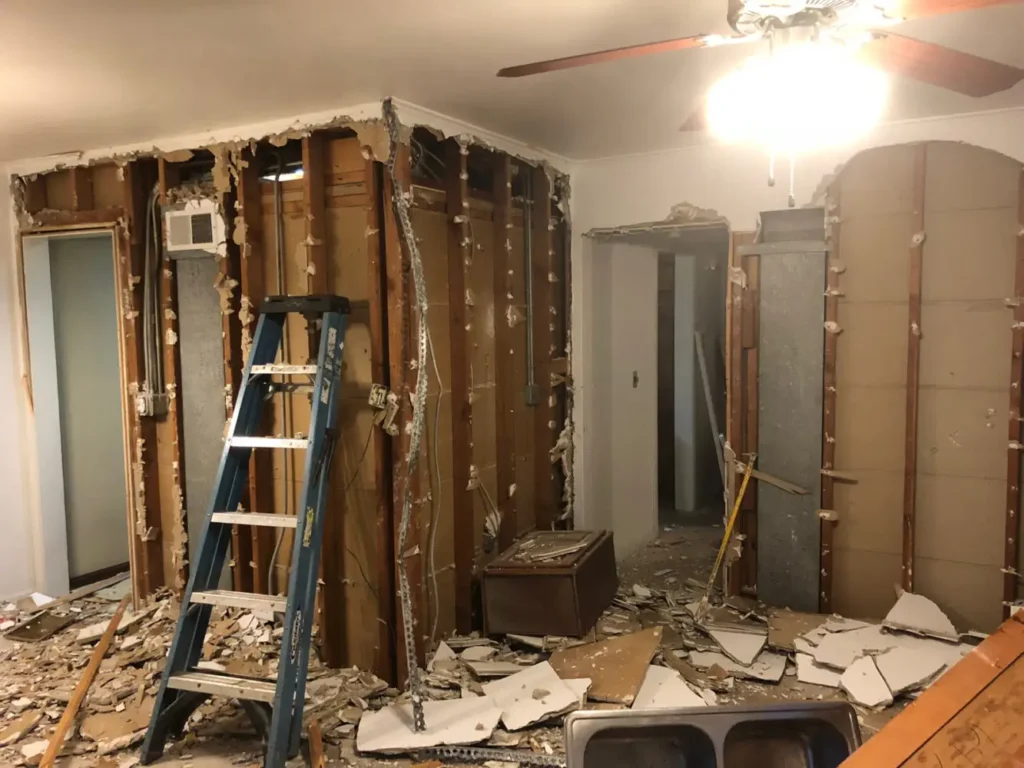 Interior demolition crew stripping drywall and studs during home renovation in Surrey, BC.